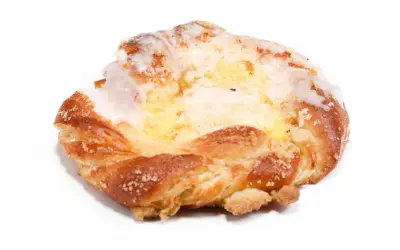 Drożdżówka z lukrem i nadzieniem, na białym tle.