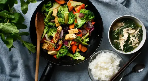 Wok z warzywami i tofu, miseczka ryżu i zupy.