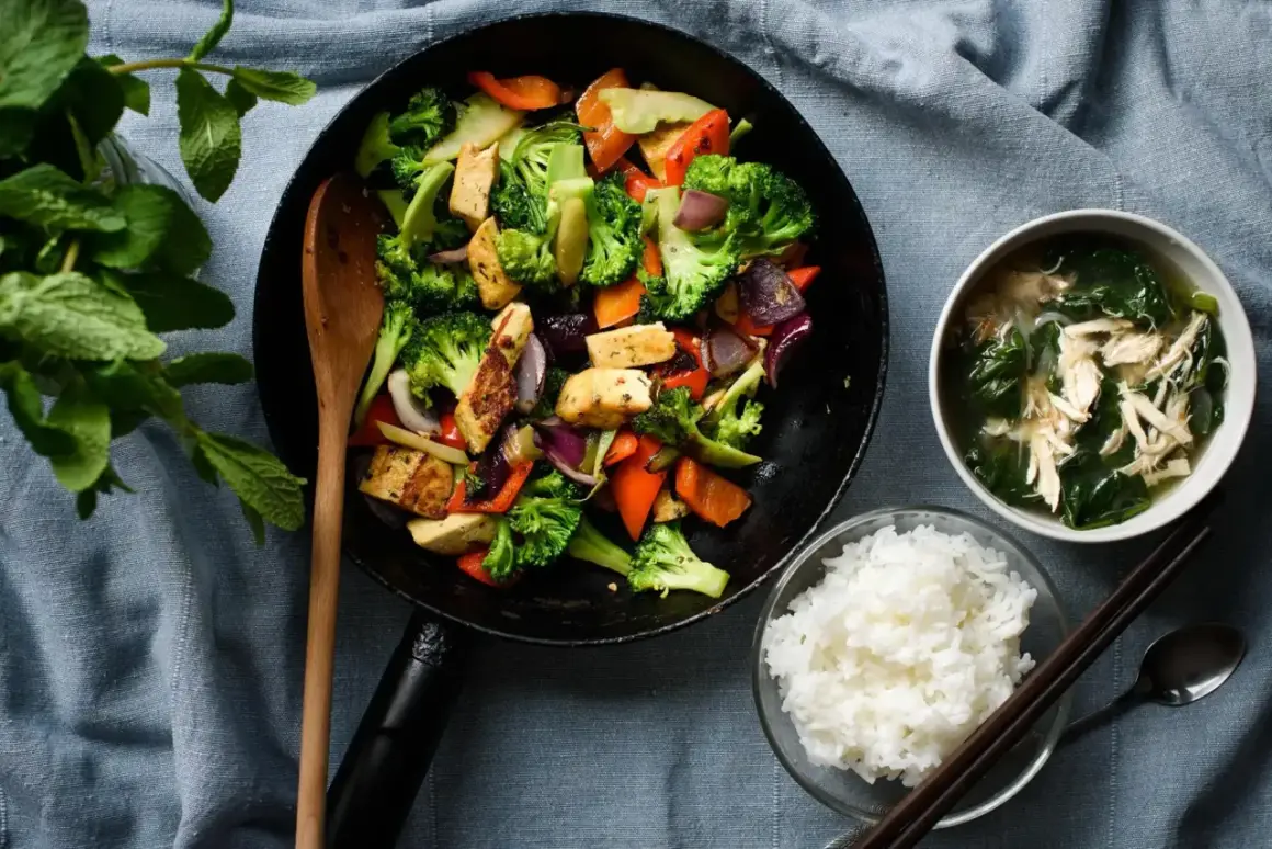 Wok z warzywami i tofu, miseczka ryżu i zupy.